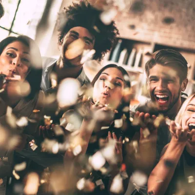 Friends Celebrating Blowing Confetti In Home Setti 2026 03 19 05 36 59 Utc