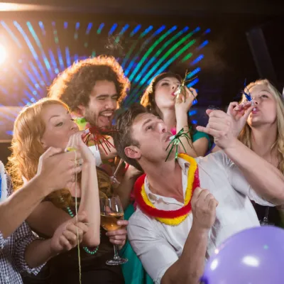 Group Of Smiling Friends Blowing Party Horn In Bar 2026 03 26 11 49 18 Utc