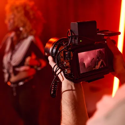 Videographer Filming A Performer Under Red Stage L 2026 03 24 07 32 10 Utc